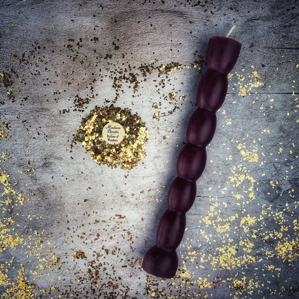 Aubergine seven knob candle, darker than the plum and lit from the side.