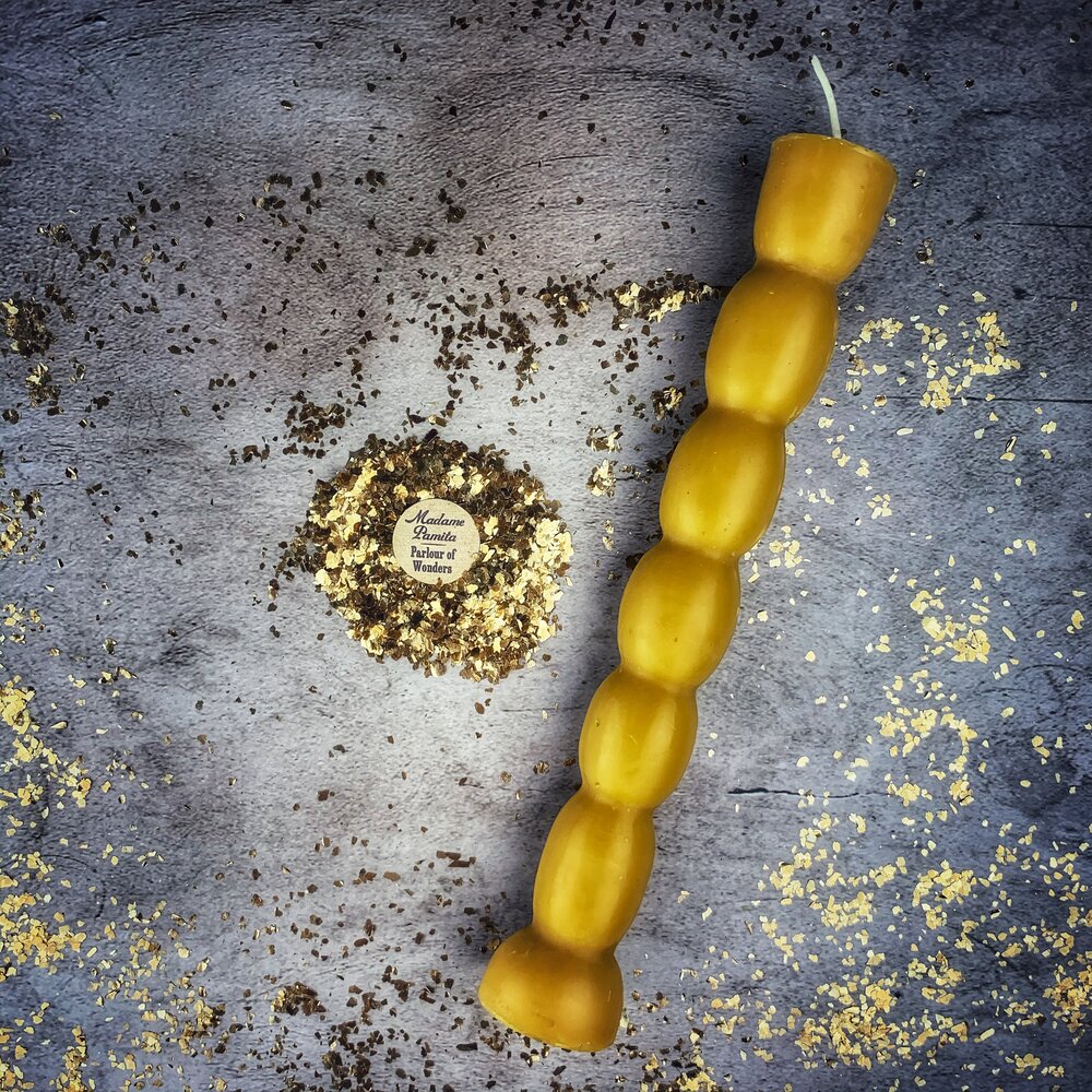 Golden-yellow seven knob candle, the beeswax translucent along the knobs.