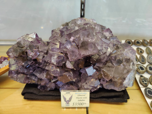 Cluster of sharp purple cubic fluorite crystals with dark sphalerite on natural matrix