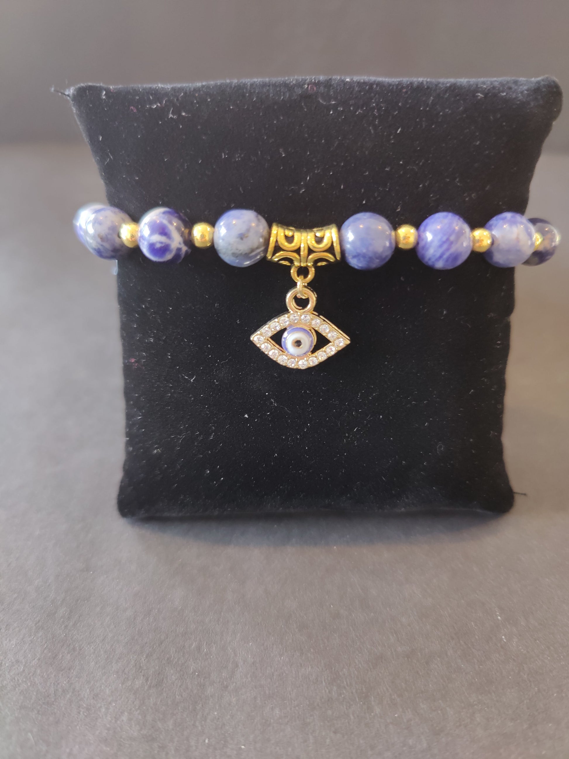 Beaded bracelet of deep blue sodalite stones with a blue and white evil eye charm