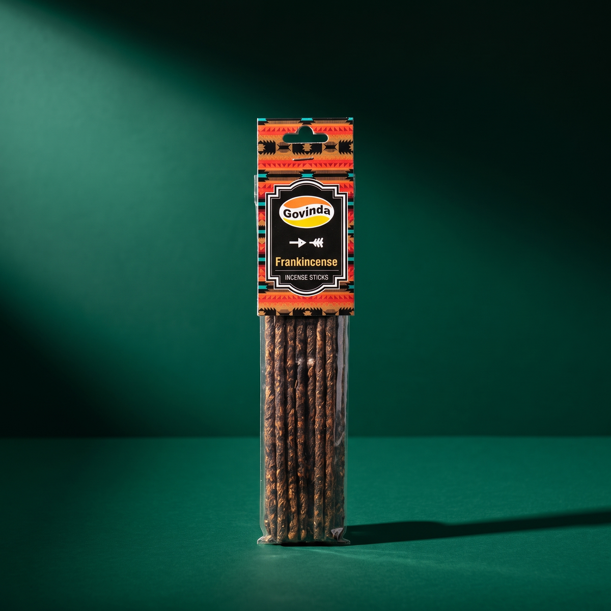 Govinda Frankincense hand-rolled incense packet standing upright on a deep green studio background