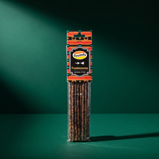 Govinda Frankincense hand-rolled incense packet standing upright on a deep green studio background