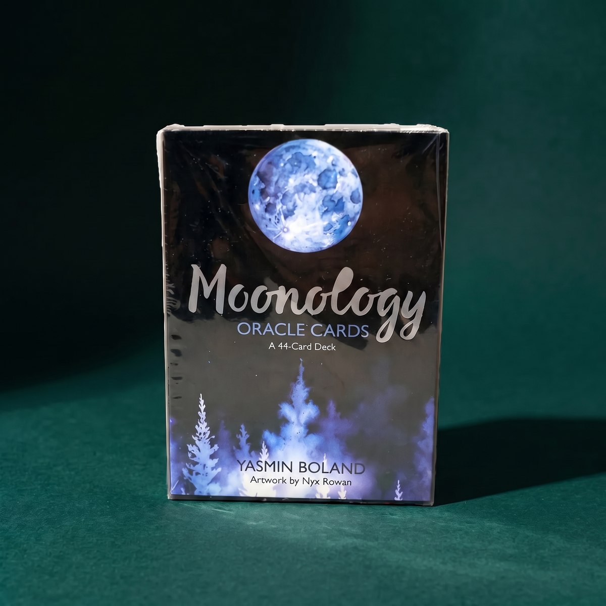 Front of the Moonology Oracle Cards box: a full moon above a pine treeline, marked A 44-Card Deck, Yasmin Boland, artwork by Nyx Rowan