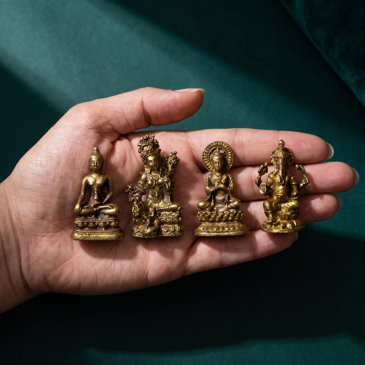 The four miniature brass figures resting on an open palm to show how small they are