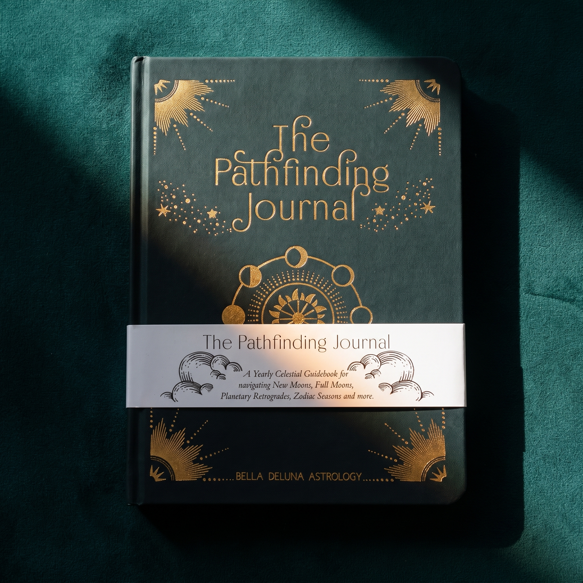 The Pathfinding Journal upright on dark green velvet, belly band reading A Yearly Celestial Guidebook