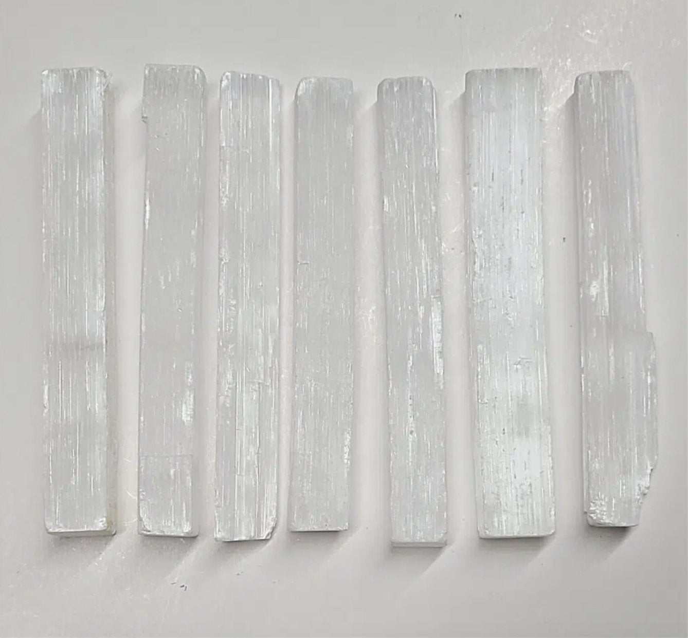Three-inch pearly white selenite stick with fine vertical striations