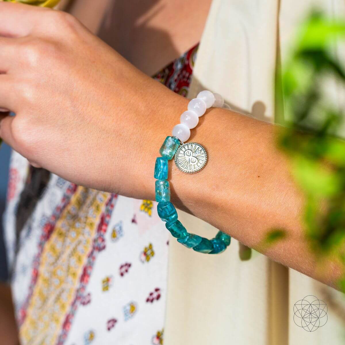Bracelet with raw blue apatite and translucent selenite beads joined by a platinum-plated infinity charm — detail view 2