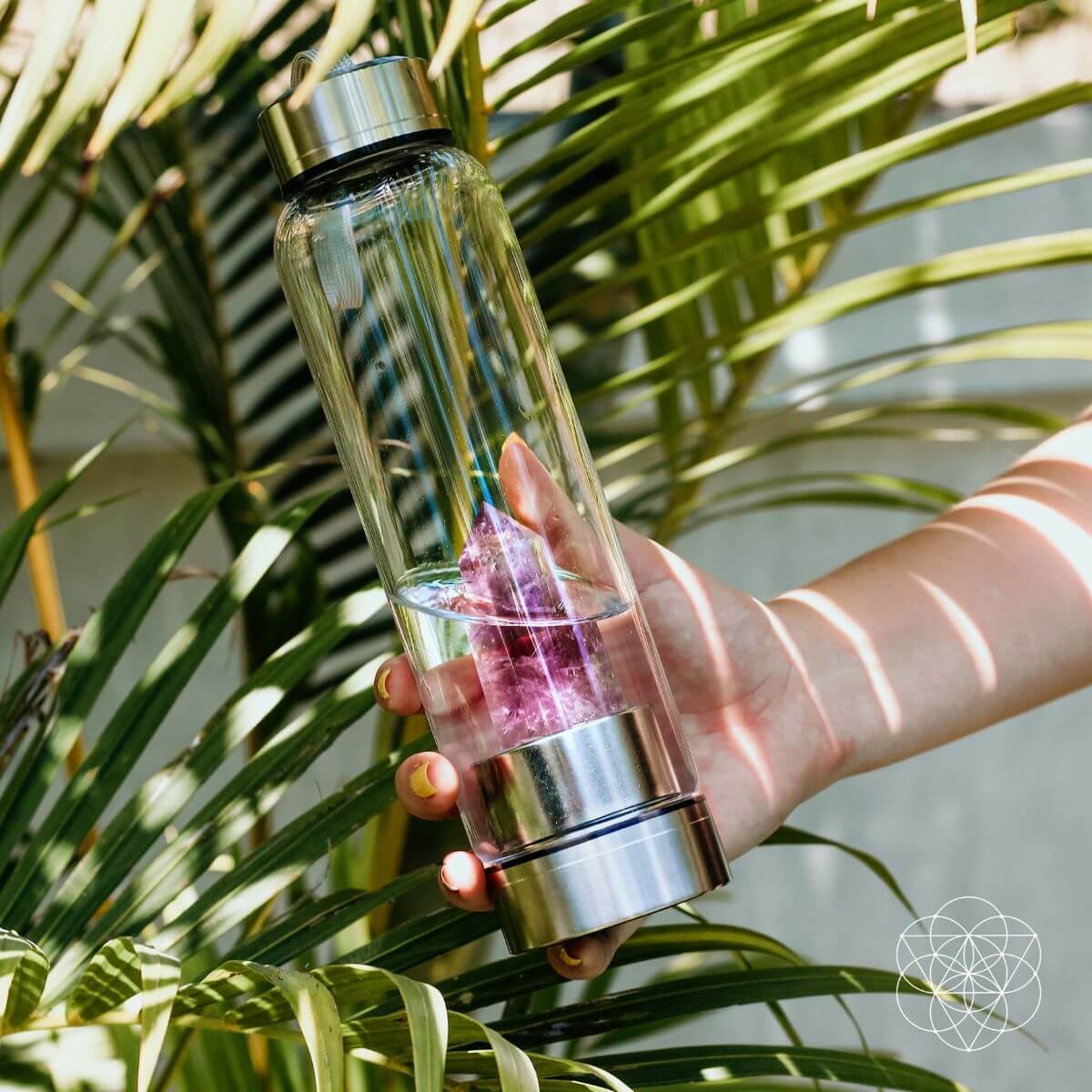 Glass water bottle with a natural amethyst crystal point set into the base — view 1 of 6