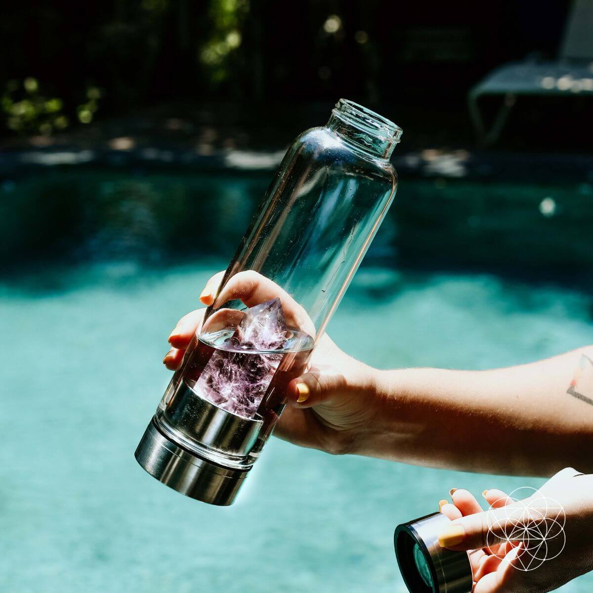 Glass water bottle with a natural amethyst crystal point set into the base — view 4 of 6