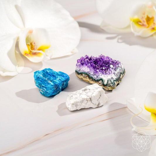 Three raw calming stones — purple Amethyst, blue Apatite, and white Howlite