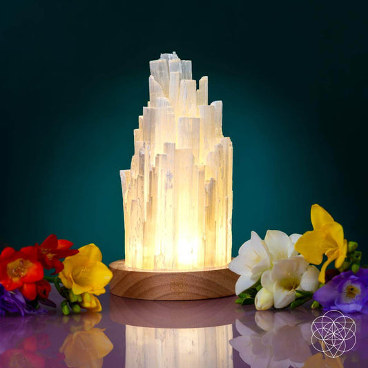 Tall Selenite crystal lamp glowing on a walnut base