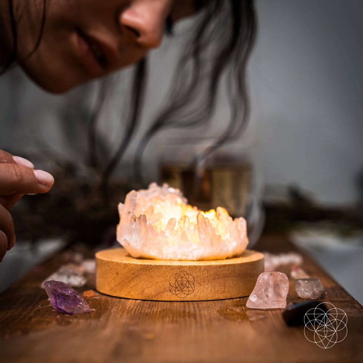 Clear quartz crystal lamp glowing softly on a wooden base — detail view 2