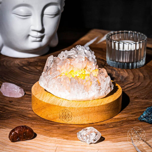 Clear quartz crystal lamp glowing softly on a wooden base