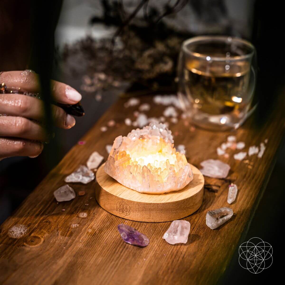 Clear quartz crystal lamp glowing softly on a wooden base — detail view 3