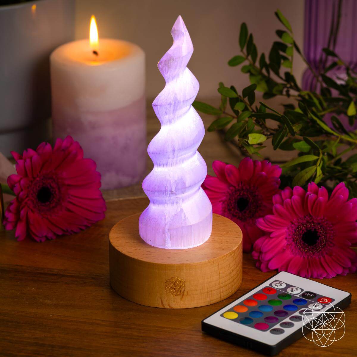 Handmade selenite flame lamp rising from a wooden base, lit in soft color — detail view 2