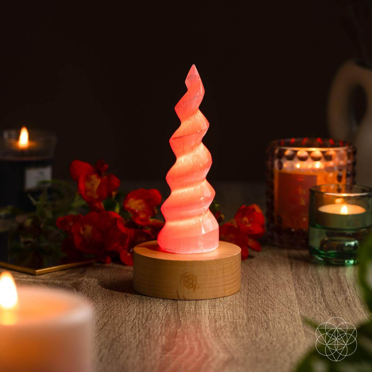 Handmade selenite flame lamp rising from a wooden base, lit in soft color — detail view 5