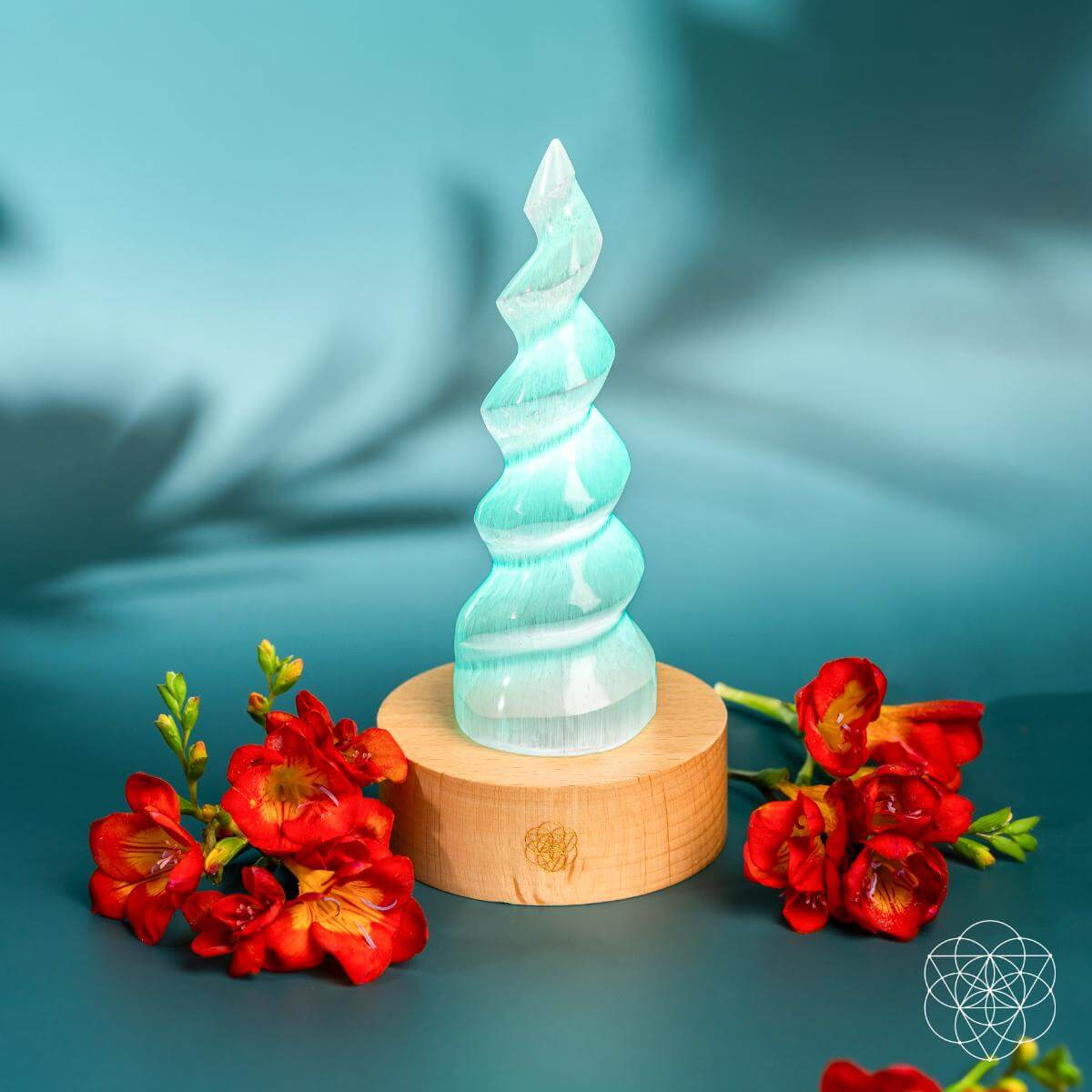 Handmade selenite flame lamp rising from a wooden base, lit in soft color — detail view 3
