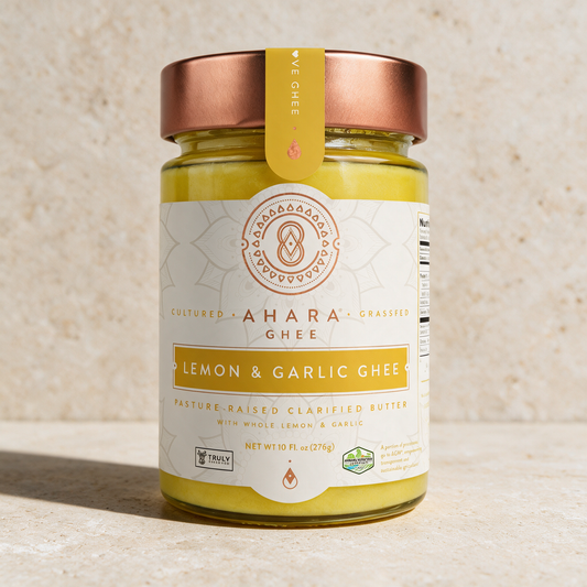 Ahara Rasa Lemon and Garlic ghee in the 10 fl oz jar with a copper lid and yellow label on pale stone