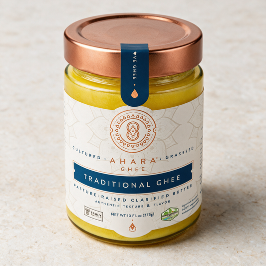 Ahara Rasa Traditional ghee in the 10 fl oz jar with a copper lid and navy label on pale stone