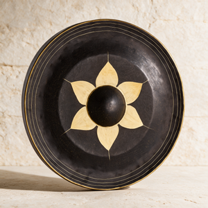 20-inch Thai gong standing against a pale plaster wall, gold lotus petals radiating from the dark center boss